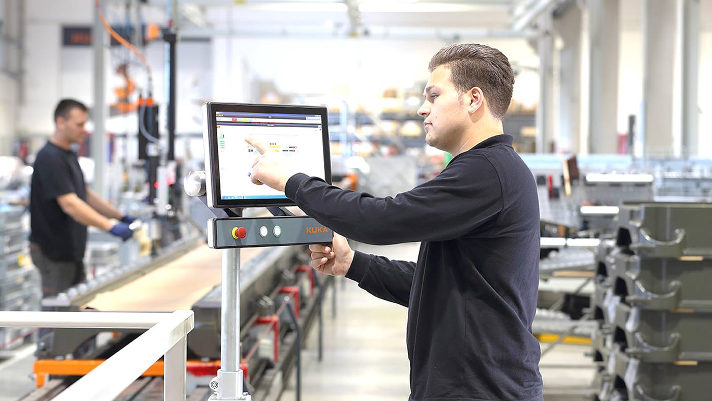 Ein Werker bei der Bedienung der miKUKA-Steuerung.